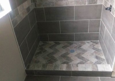 Bathroom shower with brown tiles.