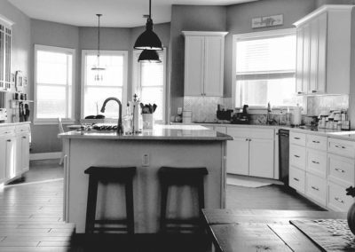 A grey picture of an open space kitchen with a small island in the middle.